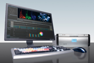 A computer monitor displaying video editing software next to a specialized keyboard, mouse, and hardware unit.