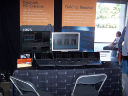 A display booth with two monitors, editing consoles, and promotional banners for DeckLink HD Extreme and DaVinci Resolve.