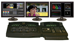 Three monitors displaying video editing software, a close-up of a woman, and audio waveforms above a control console.