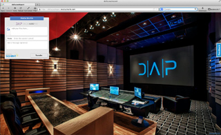 A dark media control room featuring a large screen with a blue DAP logo and a mixing console.