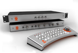 Two rack-mounted audio processors and a curved control surface with various knobs and buttons.