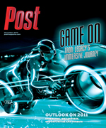 A figure in a glowing blue suit rides a light cycle with glowing blue lines emanating from it, against a dark background.