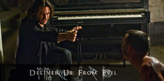A man in a dark shirt points a handgun at a shirtless man in a dimly lit room with a piano.