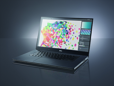 A dark Dell laptop sits on a reflective surface, displaying a vibrant, multicolored abstract pattern on its screen.