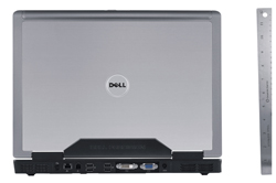 Back view of a silver Dell laptop positioned next to a vertical ruler for scale.