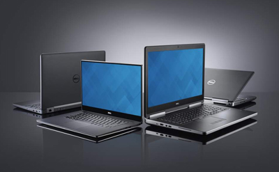 Four Dell laptops arranged on a dark reflective surface against a gray gradient background.