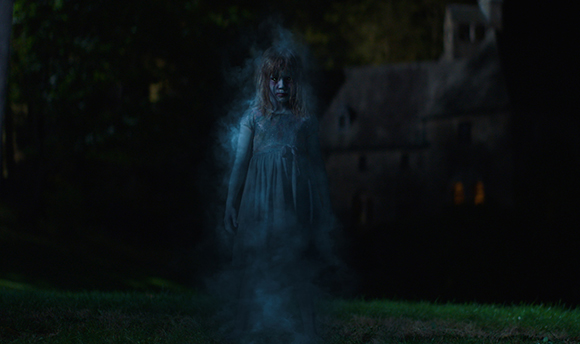 A translucent, glowing figure of a girl in a white dress standing in a dark field at night.