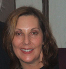 A smiling woman with shoulder-length brown hair looking toward the camera.