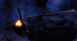 A dark, large vessel with glowing orange thrusters floating in a blue starry nebula.