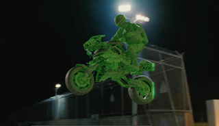 A glowing green wireframe motorcycle and rider mid-jump against a dark night background.