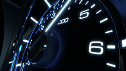 A close-up view of a dark vehicle tachometer with glowing blue numbers and markings.