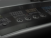 A close-up view of a black professional audio mixing console with various knobs and dials.