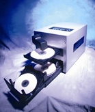 A white electronic machine with two trays holding silver optical discs.