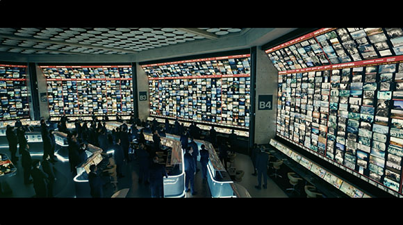 A dark control room featuring massive walls of numerous small video monitor screens.