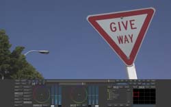 A red and white triangular 'GIVE WAY' road sign stands against a clear blue sky.