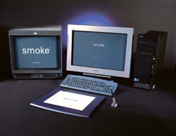 Two computer monitors displaying the word smoke, a keyboard, a graphics tablet, and a black computer tower.
