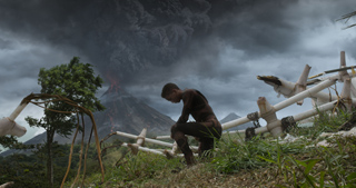 A person crouches near white wreckage under a dark, stormy sky with an erupting volcano in the distance.