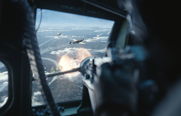 View through a cockpit window showing fighter planes flying over clouds and an explosion in the sky.