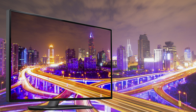 A television screen showing a brightly lit city skyline with glowing highways and skyscrapers at night.
