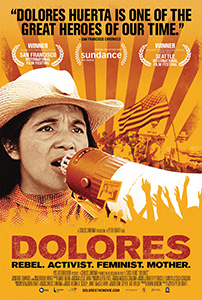 A close-up of Dolores Huerta speaking into a megaphone against an orange sunburst background.