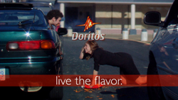 A woman in black clothing performs a plank on the ground between two parked cars under a Doritos logo.
