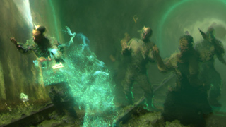 Several figures stand amidst swirling, glowing green mist and energy in a dark, cavernous setting.