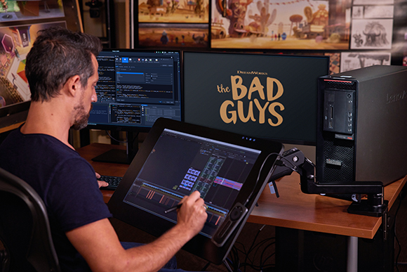 An animator uses a large digital drawing tablet and multiple monitors to work on an animated film.