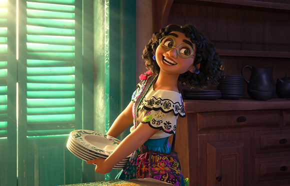 Animated girl with glasses and curly hair smiling while carrying a stack of patterned plates in a kitchen.