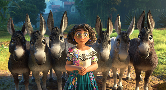 A young girl with glasses and curly hair stands centered in front of six large, expressive donkeys.