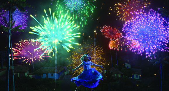 A young girl in a blue dress dances amidst colorful, exploding fireworks over a village at night.