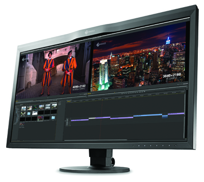 A large widescreen computer monitor showing a video editing software interface with a city skyline and people.