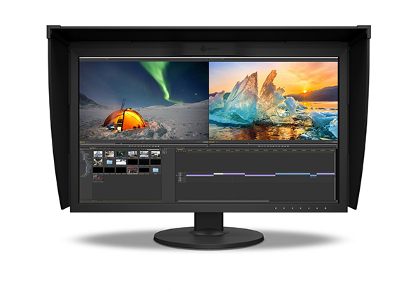A wide professional monitor showing aurora borealis and iceberg photos above a video editing timeline.