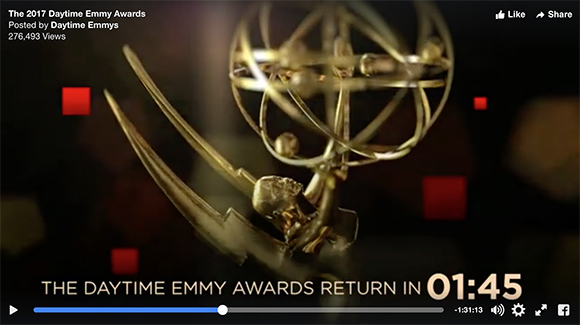 Close-up of a gold Emmy Award trophy with orbital rings and a winged base.