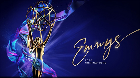 Golden Emmy statue held aloft against a dark blue background with flowing iridescent ribbons.