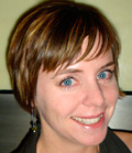 A woman with short brown hair and blue eyes smiling at the camera.