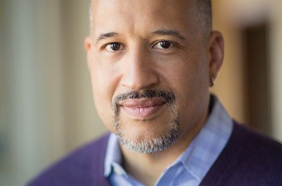 A man with short hair and a salt-and-pepper goatee smiling at the camera.
