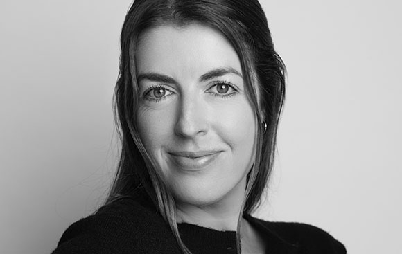 Black and white headshot of a woman with long dark hair looking toward the camera.