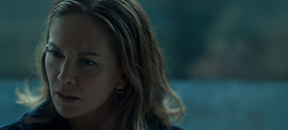 A woman with blonde hair looks off-camera with a worried or intense expression.