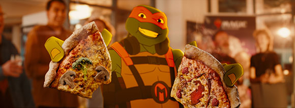 Animated green turtle wearing an orange mask holds up two large slices of pizza against a blurred background.