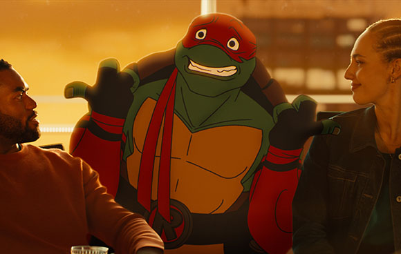 Animated red-masked turtle character placed between a man and a woman in a warm-lit setting.