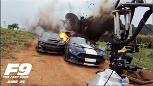 Two cars crash into each other on a dirt road during a massive explosion with dark smoke.