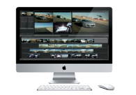 An all-in-one desktop computer with a silver stand, keyboard, and mouse, displaying a video editing interface.