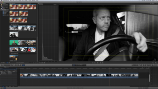 A video editing software interface displaying a black and white clip of a man driving a car.