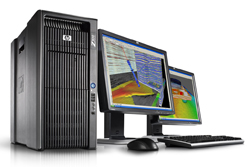 Workstation tower, two monitors showing seismic data, keyboard, and mouse.