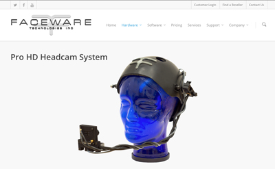 A black headcam system mounted on a blue translucent mannequin head against a white background.