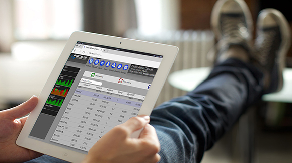 A person holds a white tablet showing a data administration console with charts and tables.