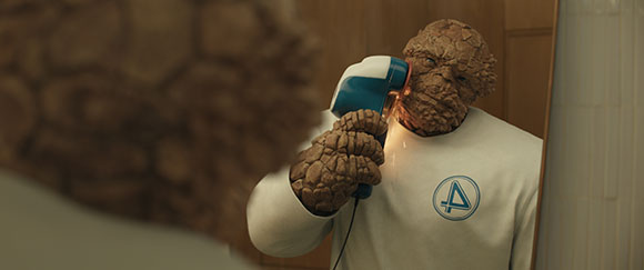 A humanoid with orange, rocky skin wears a white shirt and uses a blue and white hair dryer.