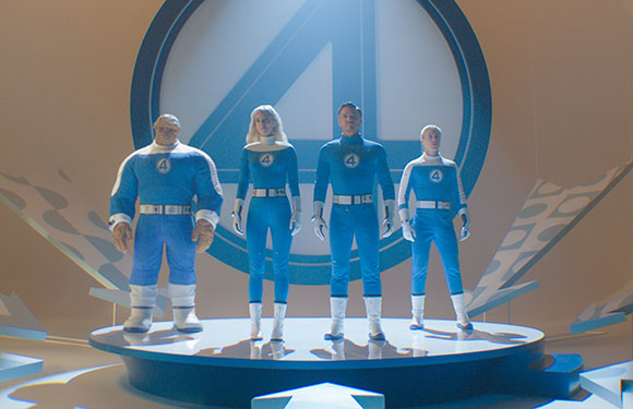Four people in blue and white superhero uniforms standing in front of a large circular logo.
