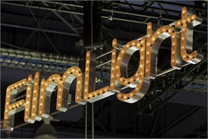 A large, silver marquee-style sign spelling 'filmlight' with glowing warm light bulbs.