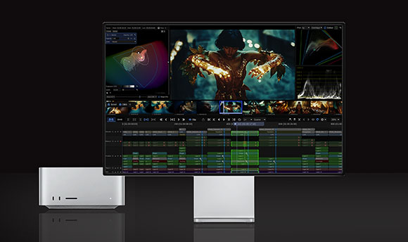A silver computer tower next to a large monitor displaying a professional video editing interface.